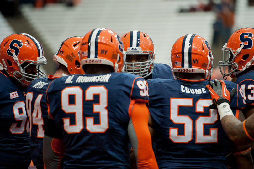 Syracuse's defensive linemen huddle around nose tackle Eric Crume before the game. 