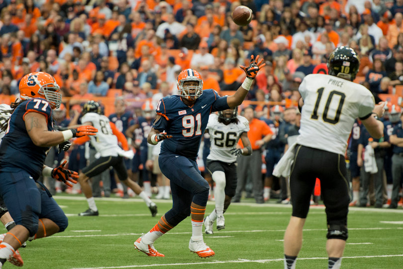Isaiah Johnson reaches up to bat down a pass by Wake Forest quarterback Tanner Smith. The SU defensive end hauled in his first career interception on Saturday.