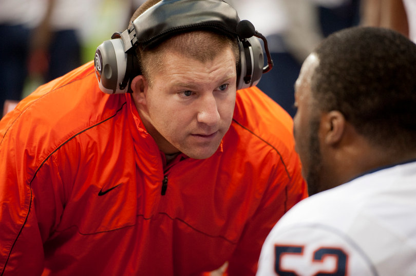 Syracuse defensive line coach Tim Daoust talks with nose tackle Eric Crume. 
