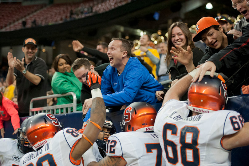 Fans and teammates mob Hunt behind the end zone following his game-winning touchdown run.