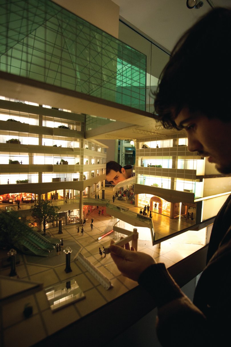 Ryan Desilva inspects the architectural model for the Syracuse Gallery, where the office is located. 