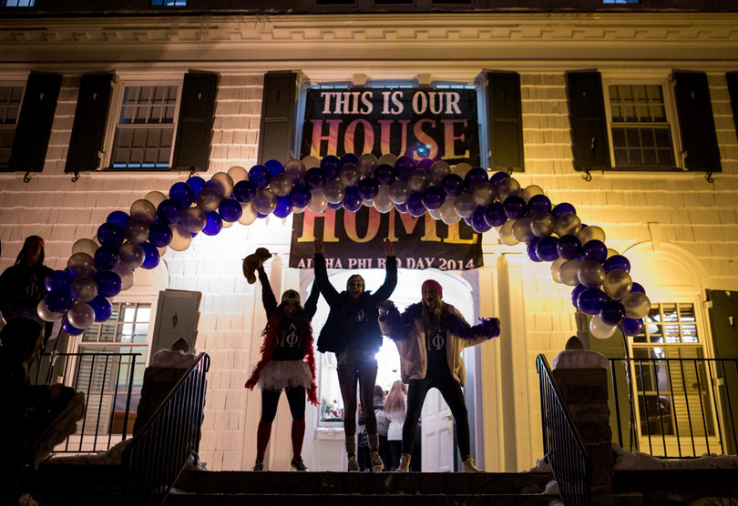 The sisters of Alpha Phi dance under a balloon archway outside their home on Walnut Avenue. Before Monday's Bid Night event, women underwent two weeks of recruitment, during which they toured houses and learned about each sorority. Bid Night, which is usually referred to as Bid Day, is the final event in the Syracuse University Panhellenic Council recruitment process. 