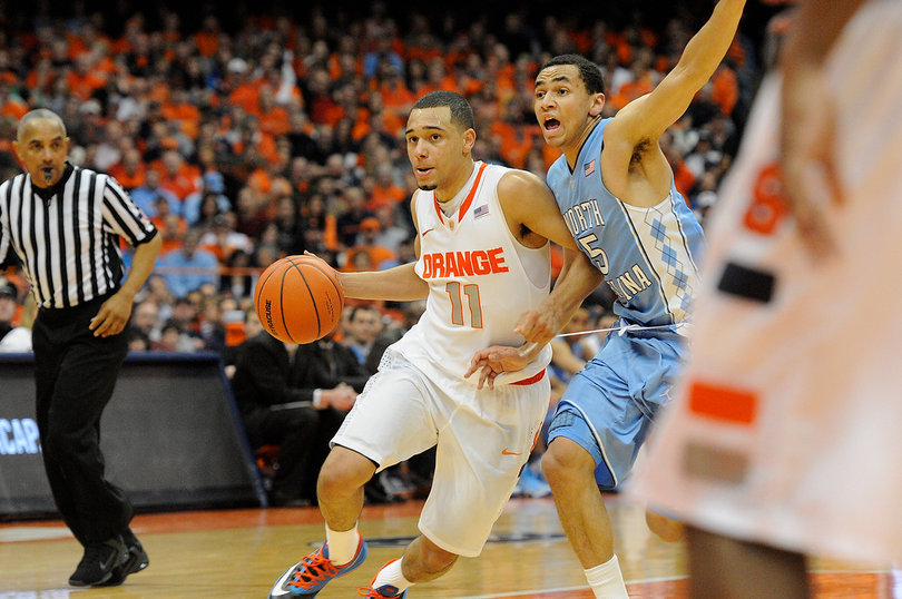 Tyler Ennis works his way past Paige and toward the rim. 
