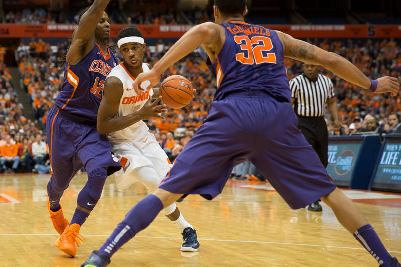 Fair drives the lane against two Clemson defenders. 