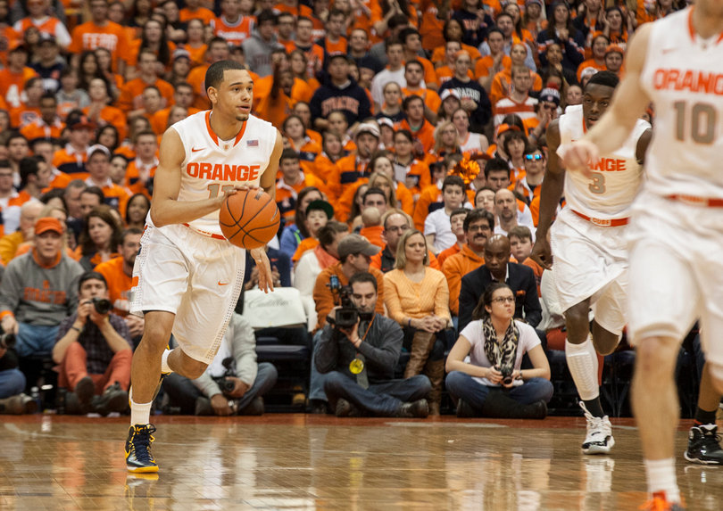 Ennis scans the floor while pushing the ball upcourt. 
