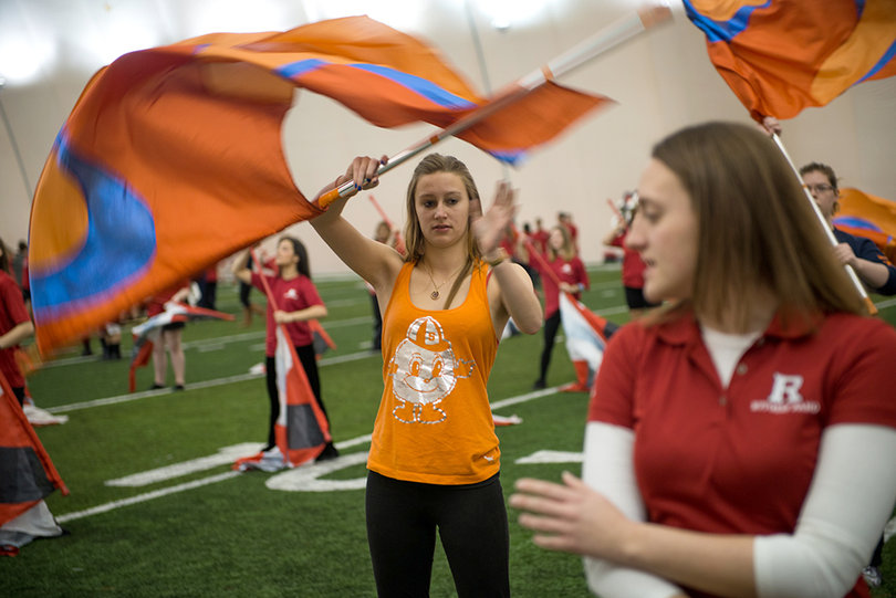 Natasha Olejar a senior marketing and retail management major, follows along with the Rutgers color guard at the practice field on Rutgers' campus on Sunday morning.