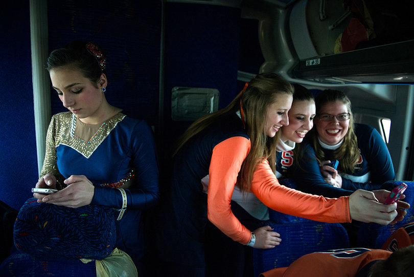 Meghan Sinisi, left, checks her phone as Natasha Olejar, Connorlynn Gaffney and Meghan Durling take a selfie at the back of their bus on the way to MetLife Stadium on Sunday afternoon.
