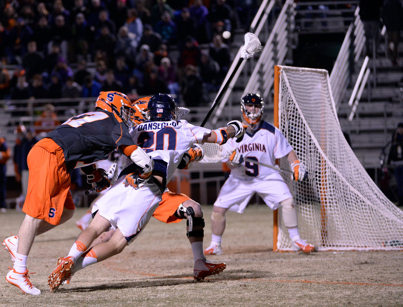 A crowd of players collide in front of the Virginia net. 
