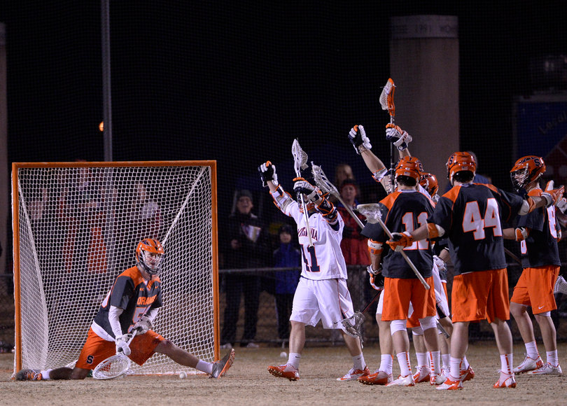 Lamolinara looks on in a split position while Virginia celebrates a goal. 