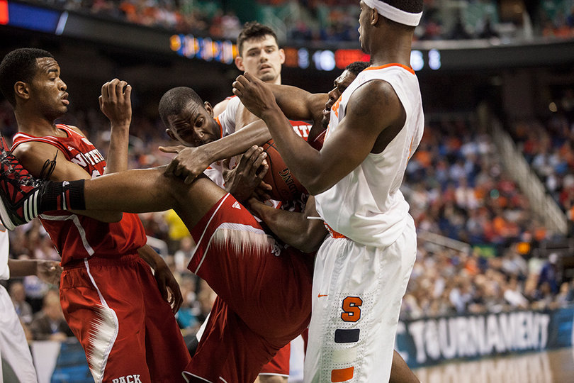 A crowd of Syracuse and N.C. State players fight for a loose ball. 