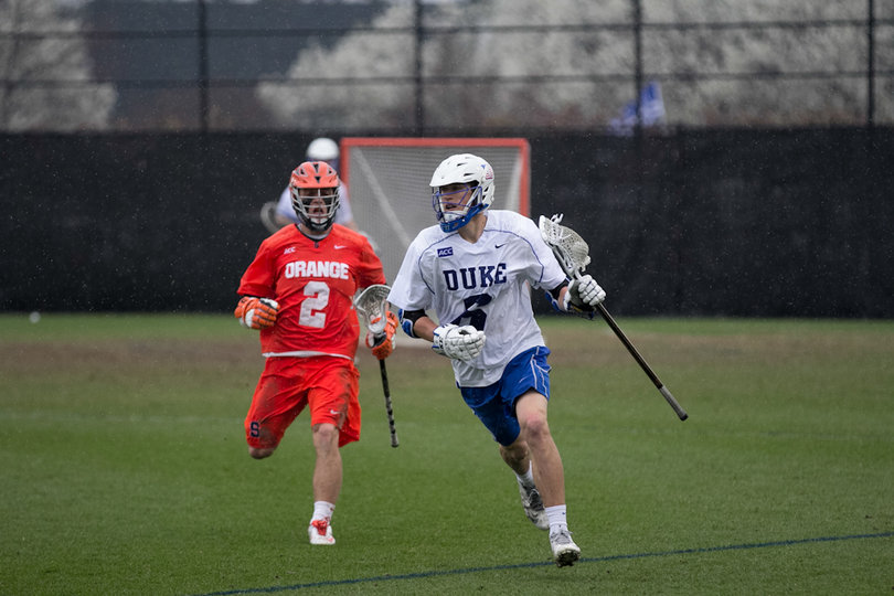 Duke midfielder Will Haus brings the ball up the sideline with Orange attack Kevin Rice close behind. 