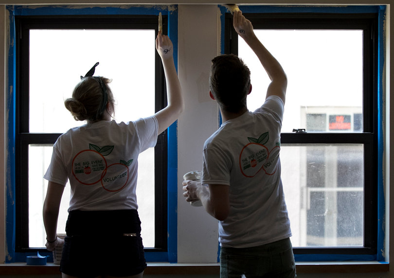 Katie Mangol and Aidan Meyer, a freshman retail management major and a freshman communication and rhetorical studies major, respectively, paint windows on Saturday as part of The Big Event, which was organized by OrangeSeeds.