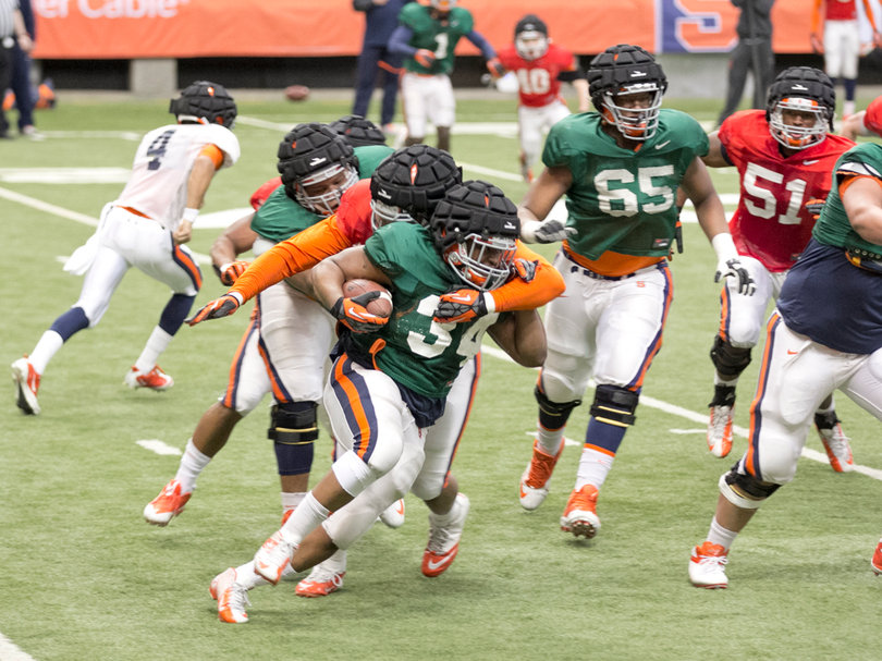 Ameen-Moore is tackled, as a defender tries to wrestle the ball loose. 