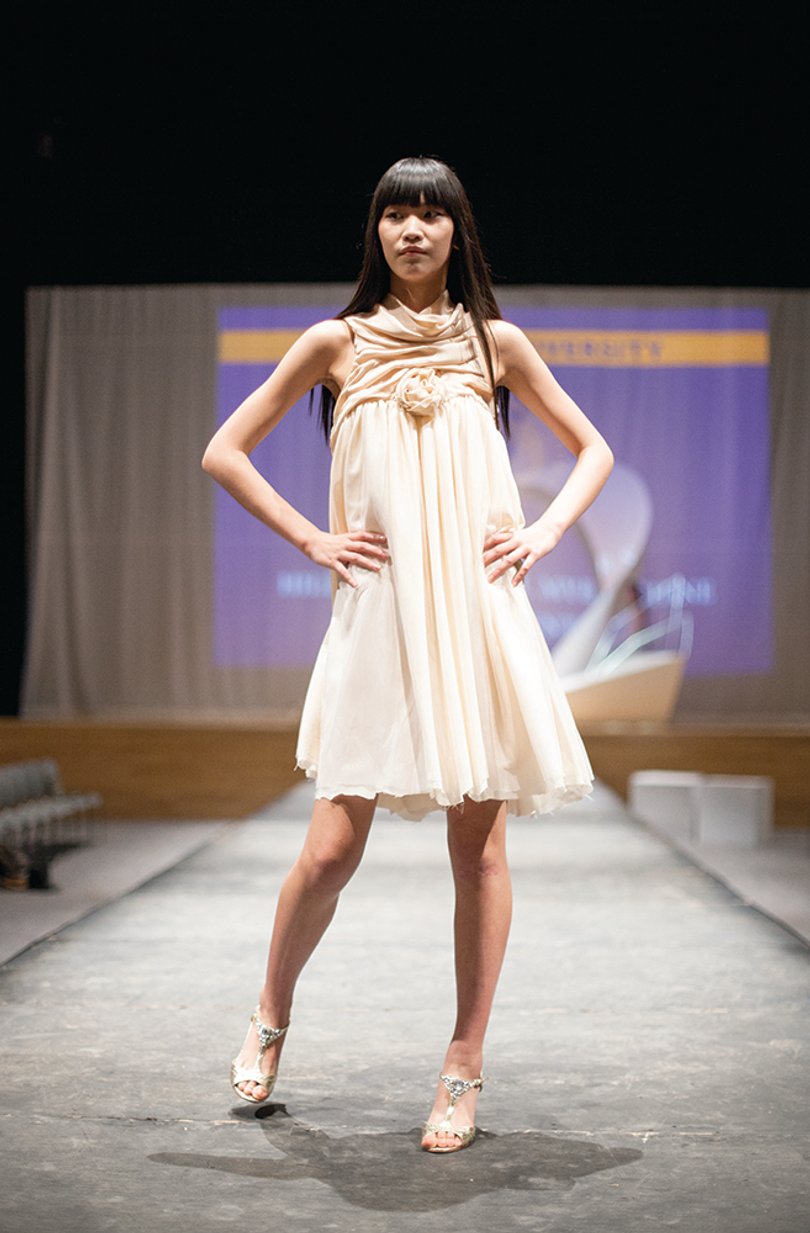 Amy Wang, a model for the upcoming Senior Collection fashion show, wears a tan and pink dress on the runway. Designers have worked on collections for three weeks.