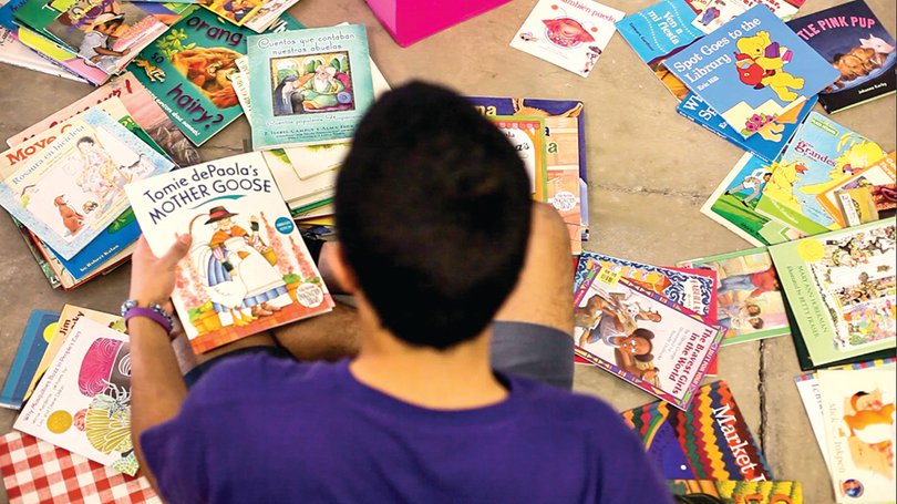 Harly Rodriguez, a senior neuroscience and psychology dual major who works at La Casita Cultural Center, sorts through children’s books. The center opened its bilingual library last April and will begin lending books in the fall.