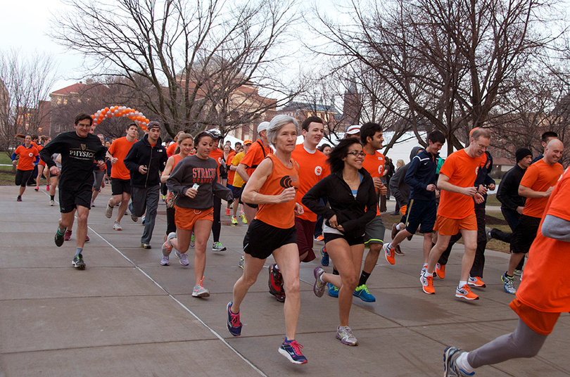 Runners race by in the quad during the Inauguration run in the quad on April 11, 2014.