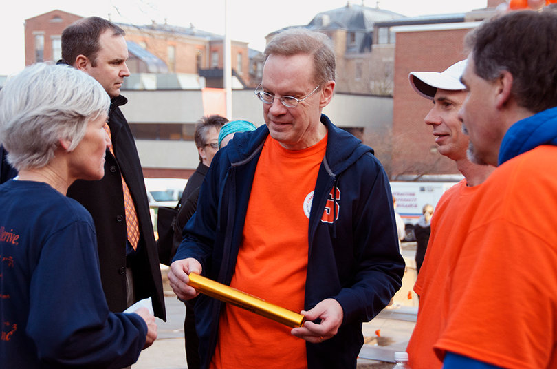 Chancellor Kent Syverud talks with Patti Ford, the commissioner of the noontime running league, and budget manager in the physics department after he received a baton from her on April 11, 2014. The baton was engraved with the words "The Syracuse University Noontime Running League welcomes Chancellor Syverud, 2014."