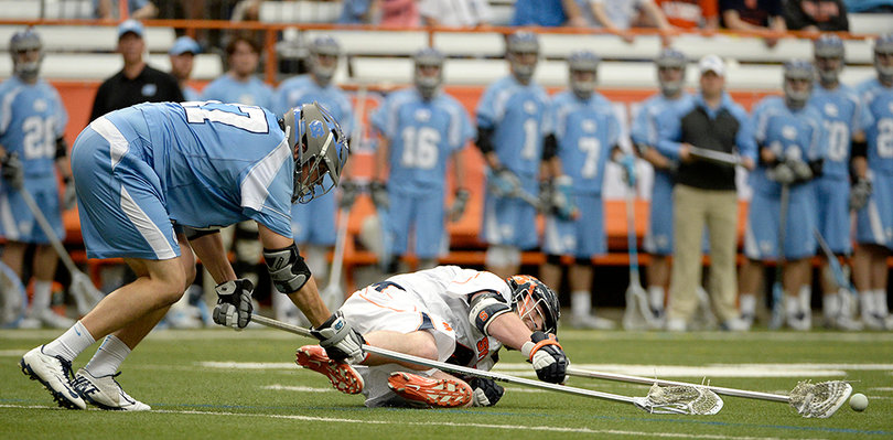 A syracuse player desperately reaches for a ground ball. 