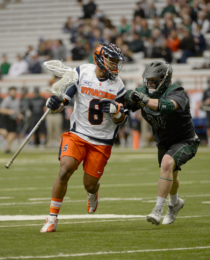Syracuse midfielder Hakeem Lecky scans the field as a defender provides pressure. 