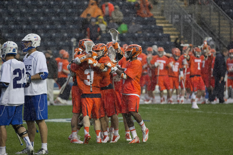 Syracuse players celebrate in the rain after a game-winning rally. 