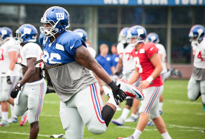 Bromley stretches before the start of practice at Giants training camp on July 27, with quarterback Ryan Nassib (9), a former SU quarterback, in the background.