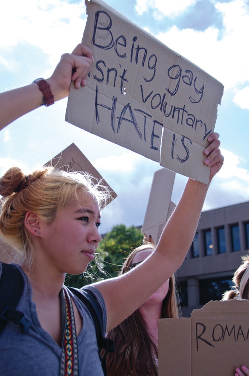 Rika Inouye, a junior photojournalism major, protested against a man preaching on Waverly Avenue who was also holding a sign intolerant toward the gay community on Wednesday. "His opinion isn't ours. We want people to know that they are safe on this campus and it isn't a place for hate," Inouye said.