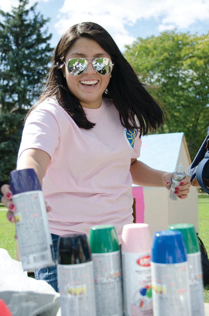 Tatiana Ospina, a sophomore mechanical engineering major, reaches for spray paint to decorate the combined Theta Tau and Alpha Omega Epsilon shack on the quad.  