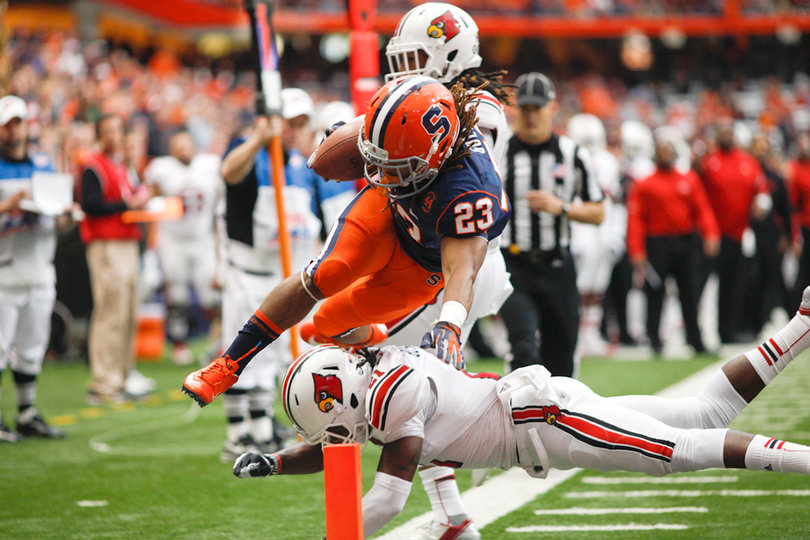 Running back Prince-Tyson Gulley hurdles a Louisville defender while diving for the end zone.