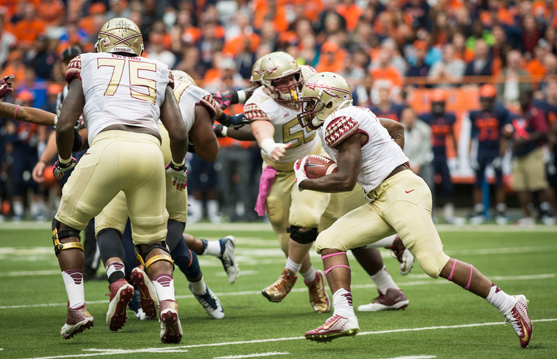 A Florida State running back moves toward a hole after receiving handoff. 