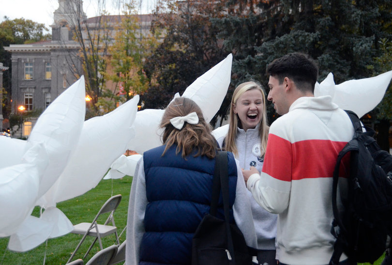Karolina Lubecka, a senior civil engineering and earth sciences dual major and 2014 Remembrance Scholar, ties balloons to chairs on the Quad prior to the balloon release event on Monday. Thirty-five dove-shaped balloons were released on Monday night to represent each of the 35 Syracuse students killed in Pan Am Flight 103. 