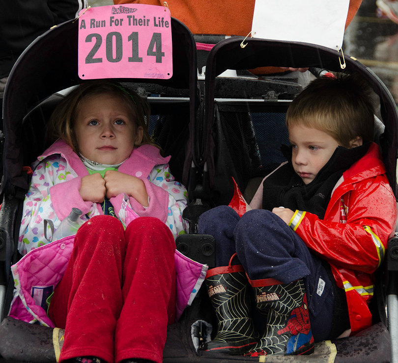 (From left) Grace Ann Gardiner and Patrick Gardiner were brought to the race by their parents. Despite the rain, roughly 800 people, dressed in mostly pink, participated in the race.