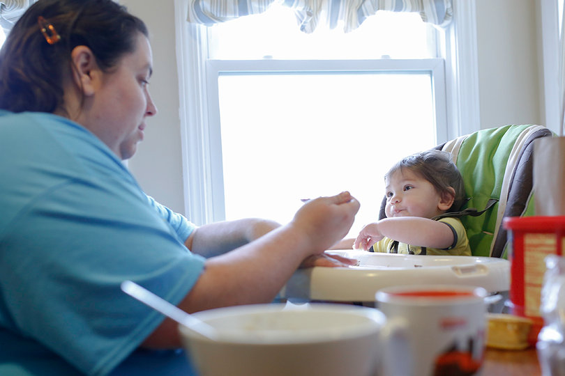 Courtney O’Dell , a doctoral student in the religion department, feeds her child. O’Dell and other SU graduate students struggle to pay child care costs.