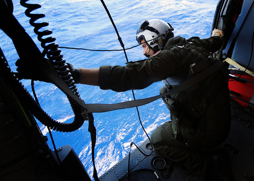 Naval Air Crewman 2nd Class Thomas Fortney, from Knoxsville, Tenn., assigned to Helicopter Sea Combat Squadron (HSC) 6 looks for a simulated survivor in the water during a drill as part of plane guard operations for the aircraft carrier USS Nimitz (CVN 68). Nimitz is underway conducting carrier qualifications in preparation for Rim of the Pacific (RIMPAC) 2012, the world's largest international maritime exercise.
