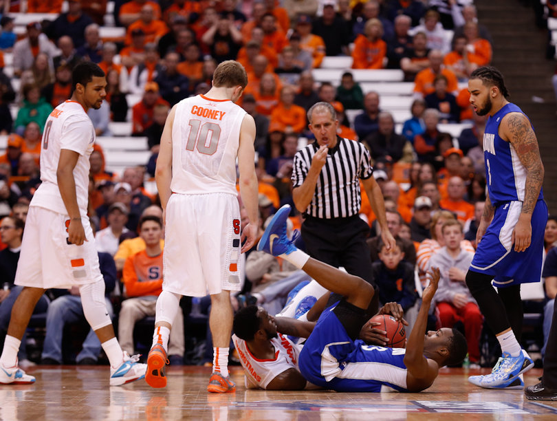 A Hampton player falls to the crowd after tangling up with an SU player and Cooney stares down at him. 