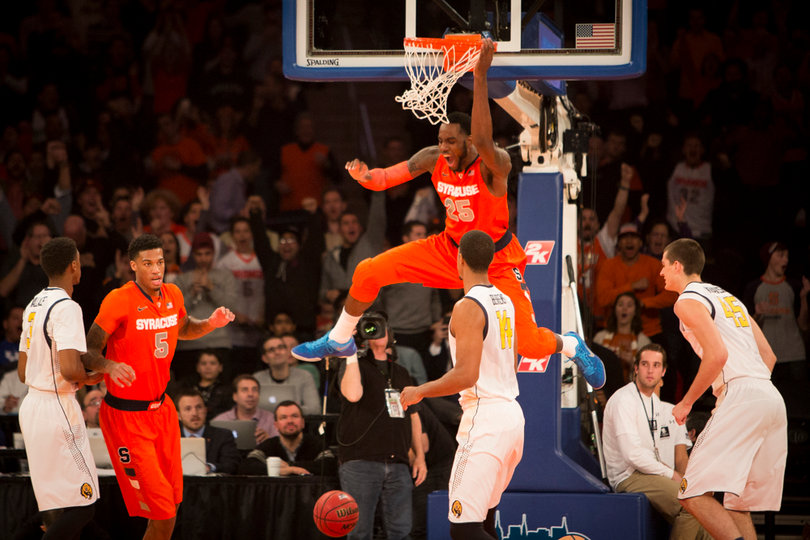 Syracuse center Rakeem Christmas hangs on the rim after throwing down an alley-oop dunk on Syracuse's first possession. 
