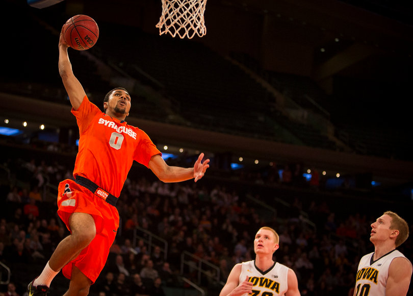 Gbinije rises for a layup as two Hawkeye defenders watch the forward soar toward the rim.