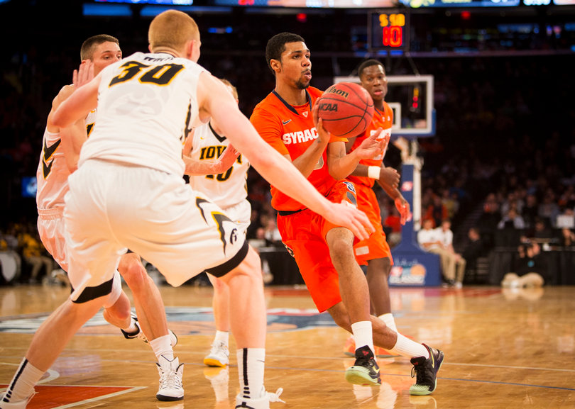 Gbinije drives the lane and look to kick it out as Iowa's Aaron White defends.