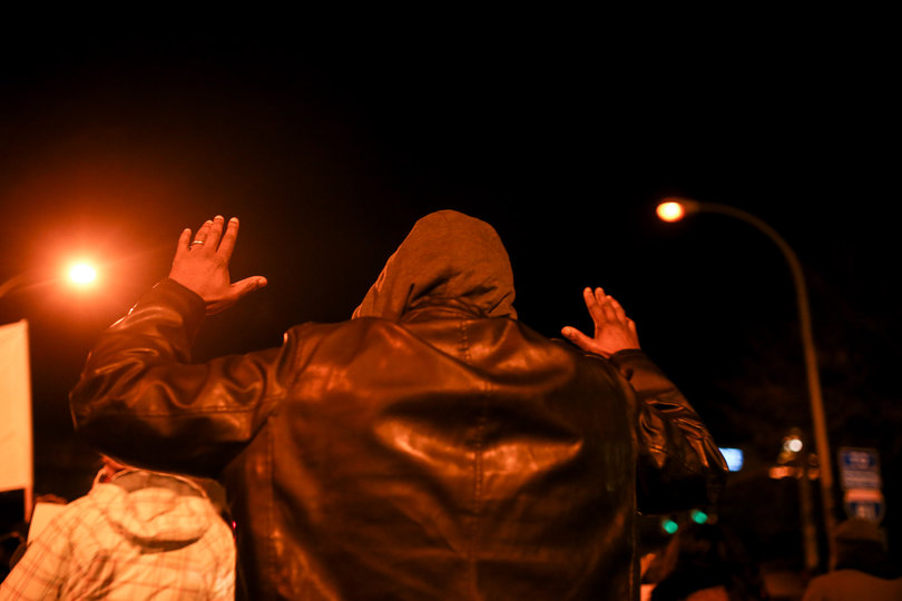 A marcher holds up his arms as protesters chanted "Hands up, don't shoot" during the "March for Justice" on Monday.