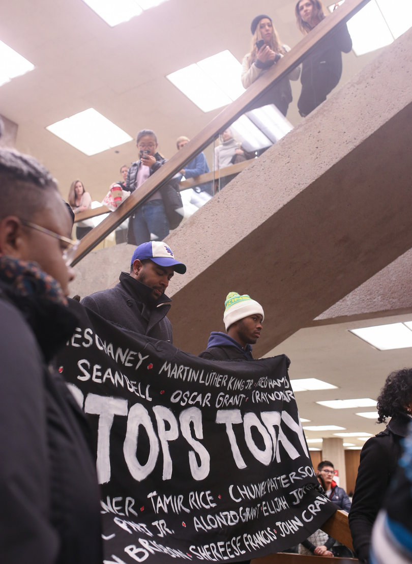 Students react as marchers participate in four and a half minutes of reflection during the "die-in" on Monday at Bird Library.
