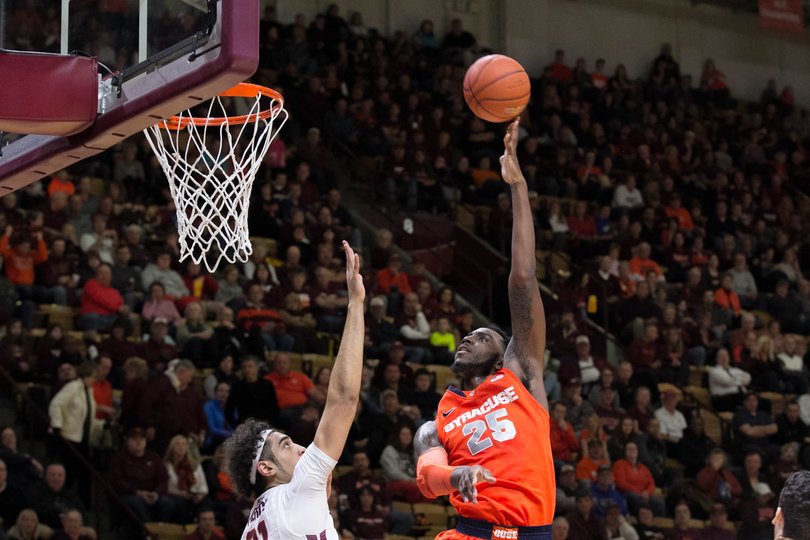 Rakeem Christmas lofts a left-handed hook shot over VT's Satchel Pierce. The SU senior had 10 points in the opening 20 minutes.