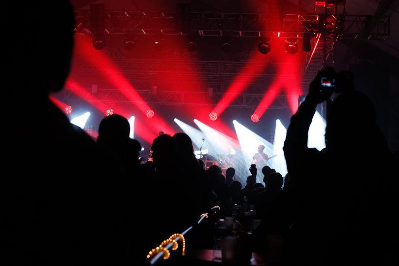 Audience members take out phones to snap photos of the band members.