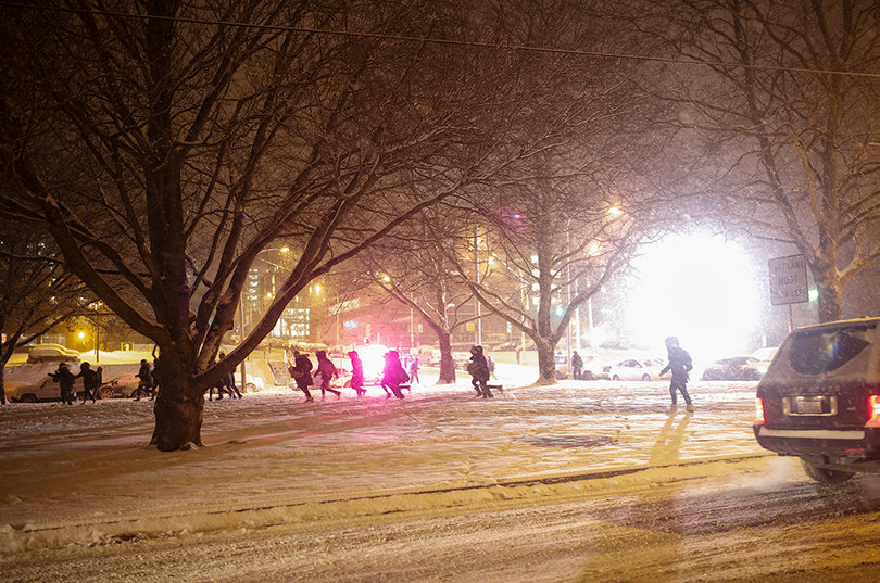 Women run across Walnut Park back to their new houses after opening their bids in Schine Student Center. 