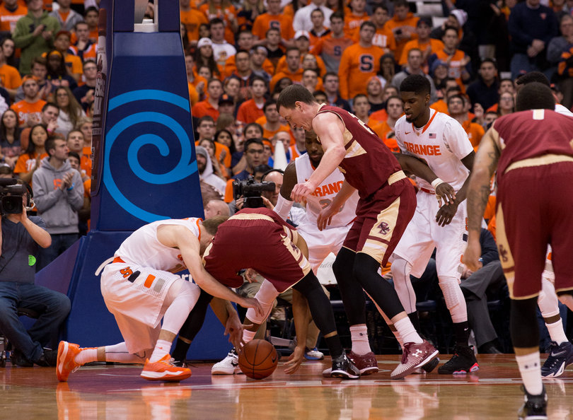 Guard Trevor Cooney scraps for a loose ball with a BC player as Christmas and B.J. Johnson look on.