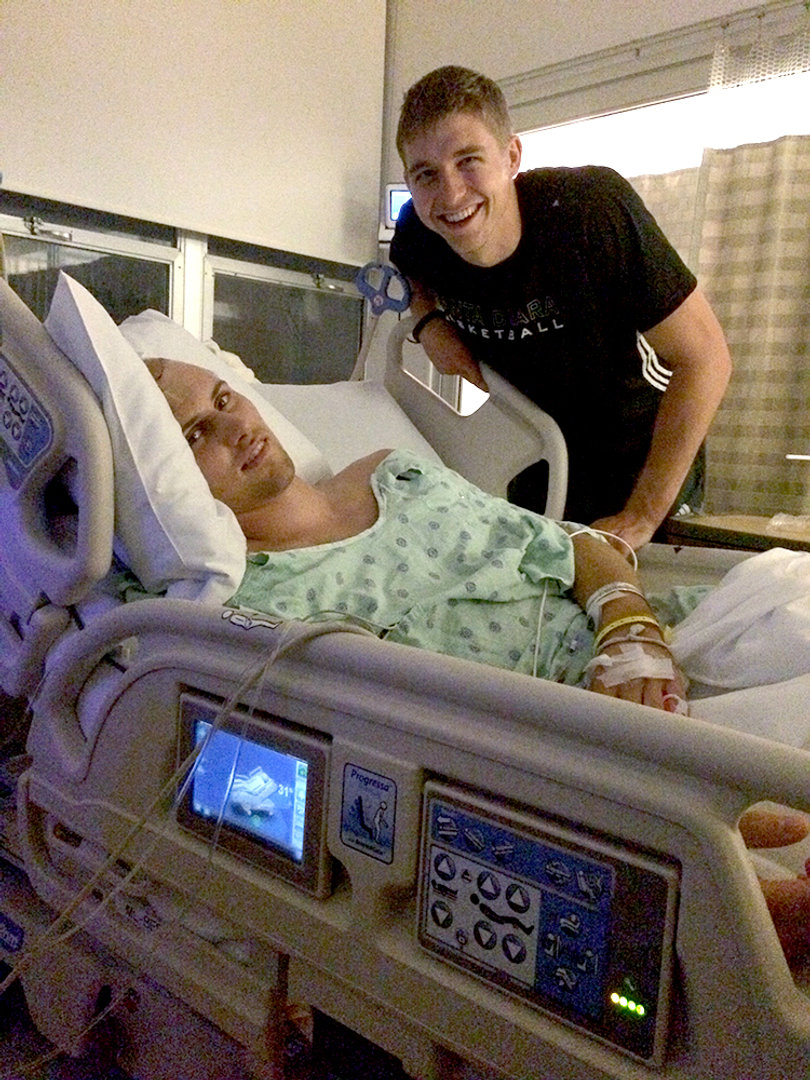Papenfus (left) lies in his hospital bed at O'Connor Hospital with teammate and best friend Nate Kratch by his side.