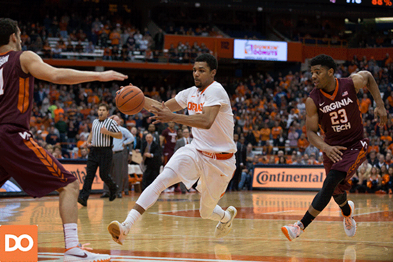 Gbinije side-steps Virginia Tech's Devin Wilson to flip up a short jumper from the paint while VT guard Jalen Hudson closes in.