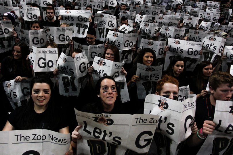 Members of Pitt's student section, also known as the "Oakland Zoo," act uninterested in the Orange by reading faux newspapers.