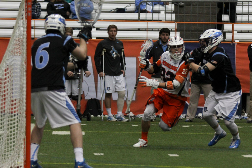 Sophomore midfielder Jordan Evans dodges toward the goal with a JHU defender guarding closely.