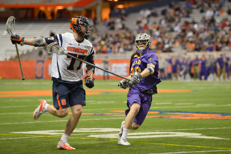 Schoonmaker holds his stick out wide as Albany's Eric Cantor tries to poke the ball away.
