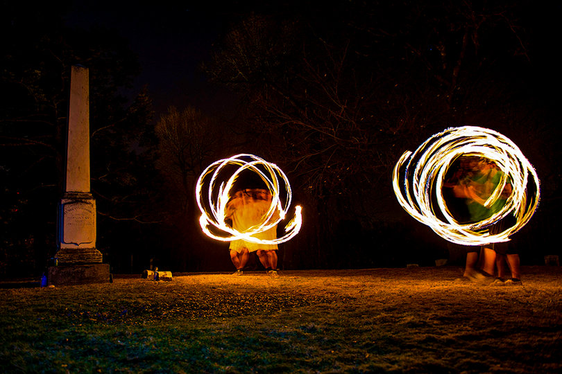 (From left) Paganakis and Brian Miller, a junior at SUNY-ESF, like to spin fire at Oakwood Cemetery. Miller picked up fire spinning at the Camp Bisco music festival in 2013. 