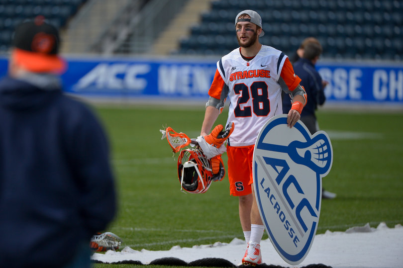 Macartney carries his equipment and an "ACC lacrosse" sign after Syracuse's win.